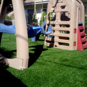 a plastic swings on a green lawn