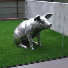 a statue of a pig on a grass field
